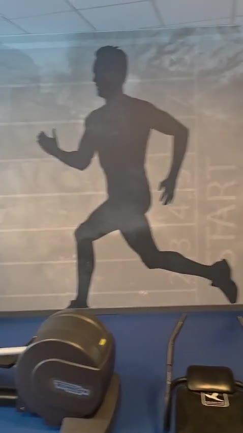 Cardio equipment in a bright fitness room with blue flooring